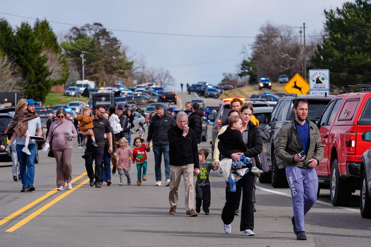 A group of families walking down a road.