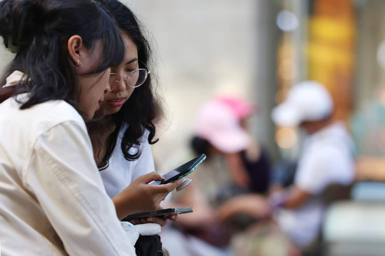 Two teenagers on their smart phones.