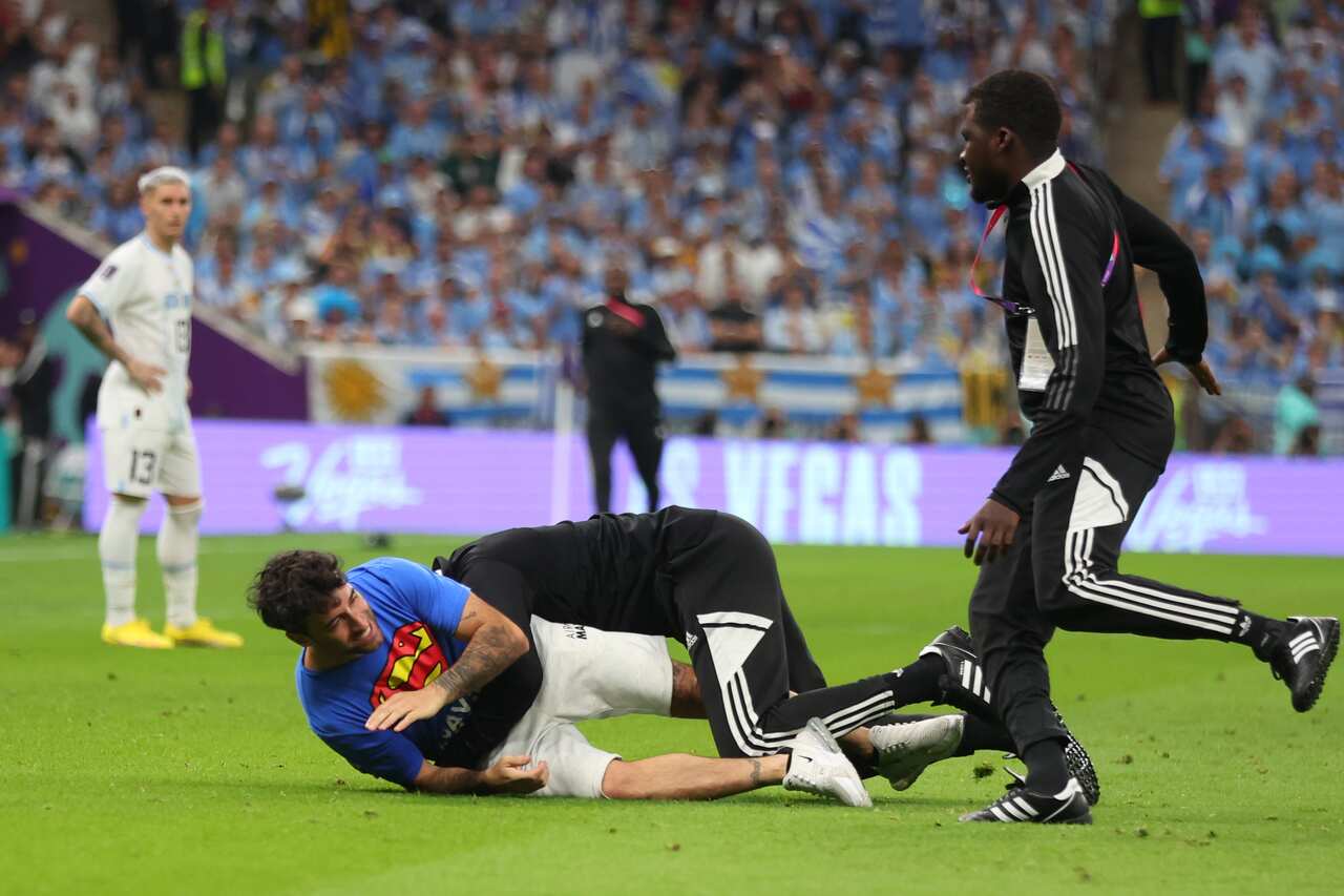 A protester is tackled by tournament officials during the Portugal v Uruguay game. 