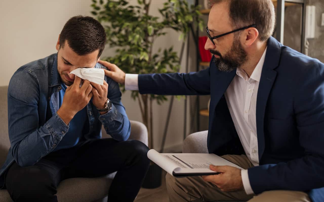 Young man crying during psychotherapy
