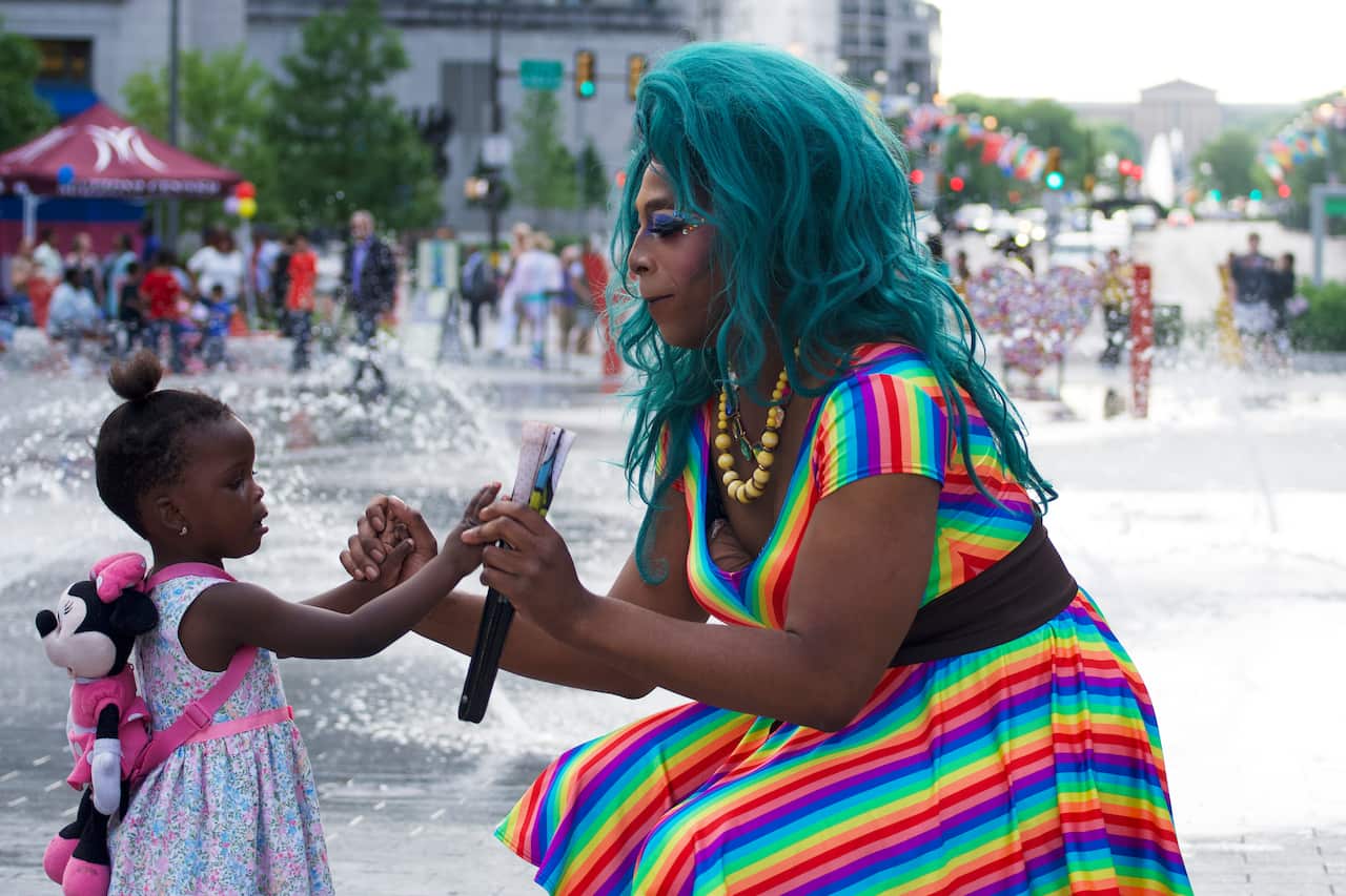 A drag queen talking to a young child.
