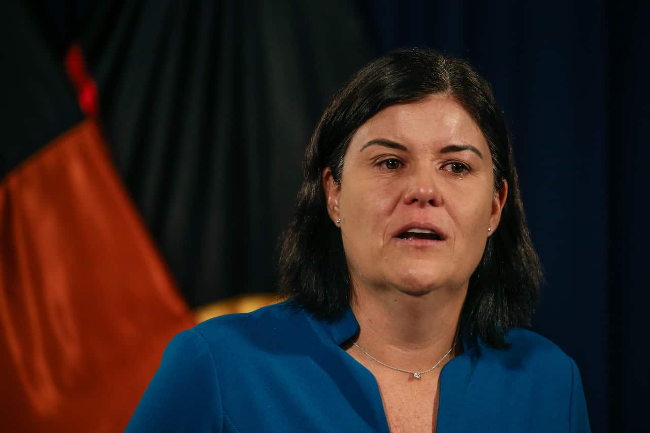 A woman in a blue blazer speaking