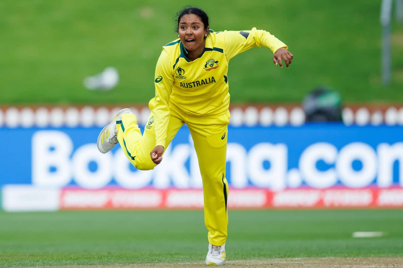 Alana King wearing a yellow outfit playing cricket for Australia 