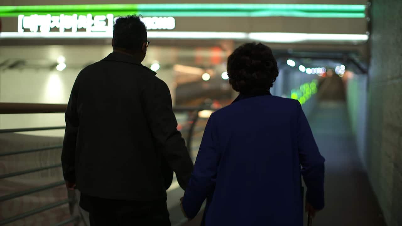 A man and a woman in a train station.