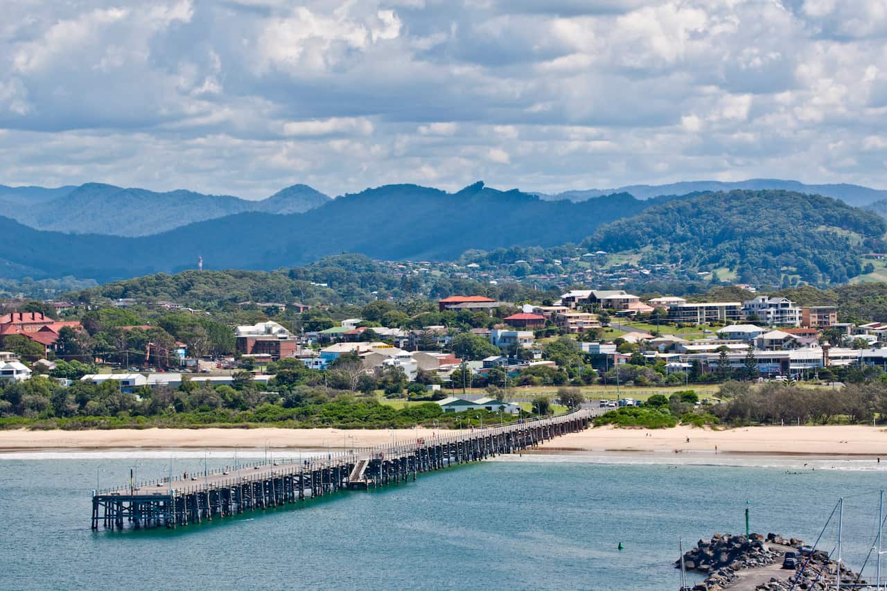 Water and a jetty. Behind are houses and mountains