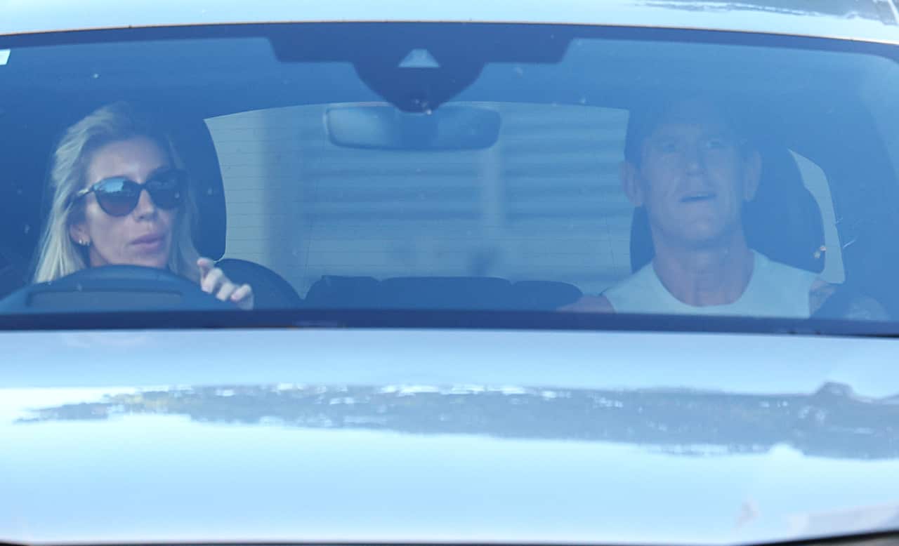 A woman and a man seen through the window of their car