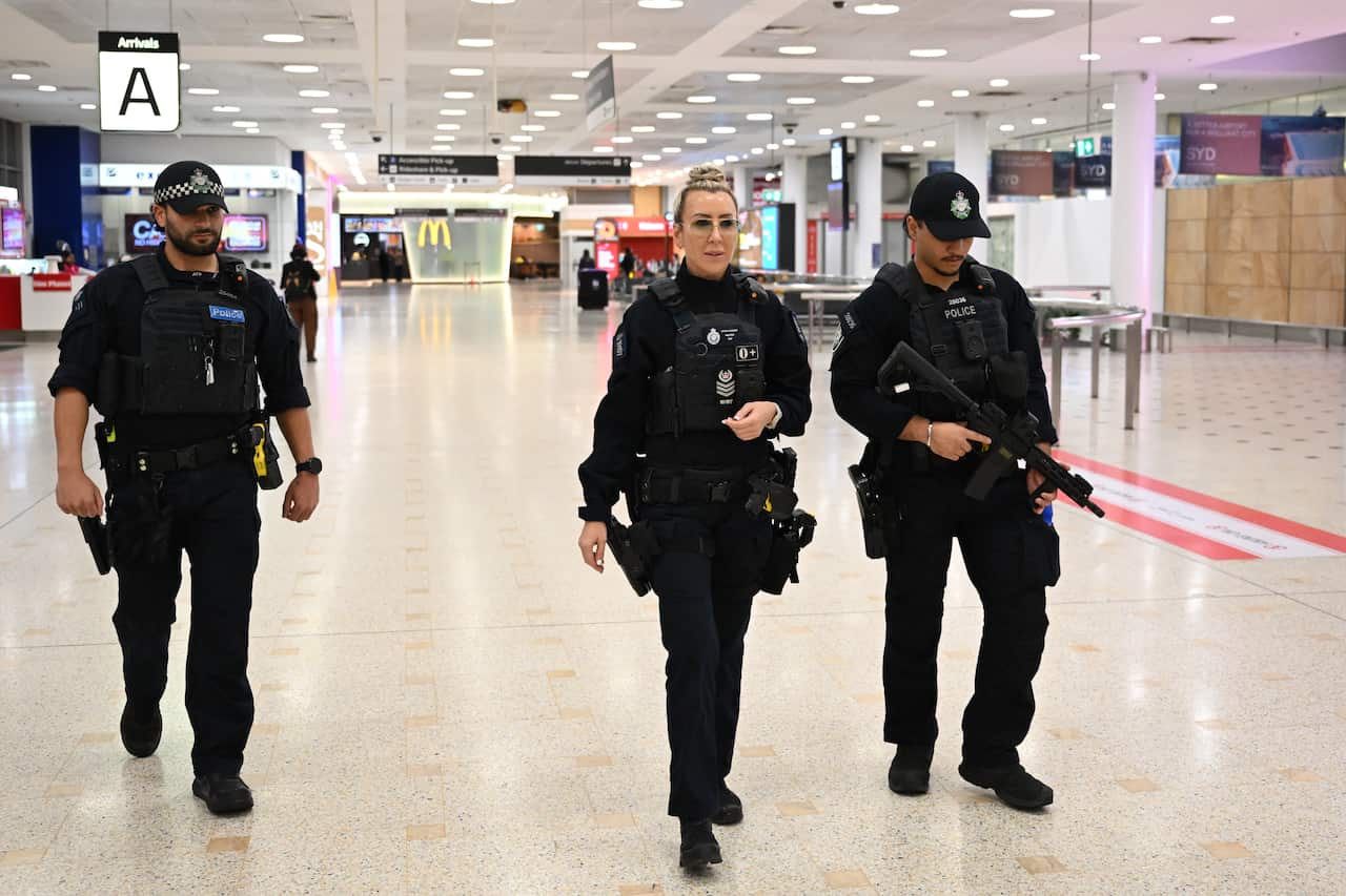 Australian Federal Police officers patrol an airport.