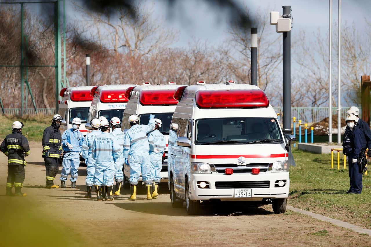 Ambulances stand by at a school ground in Shari, on the island of Hokkaido, to receive passengers from a tour boat that went missing.