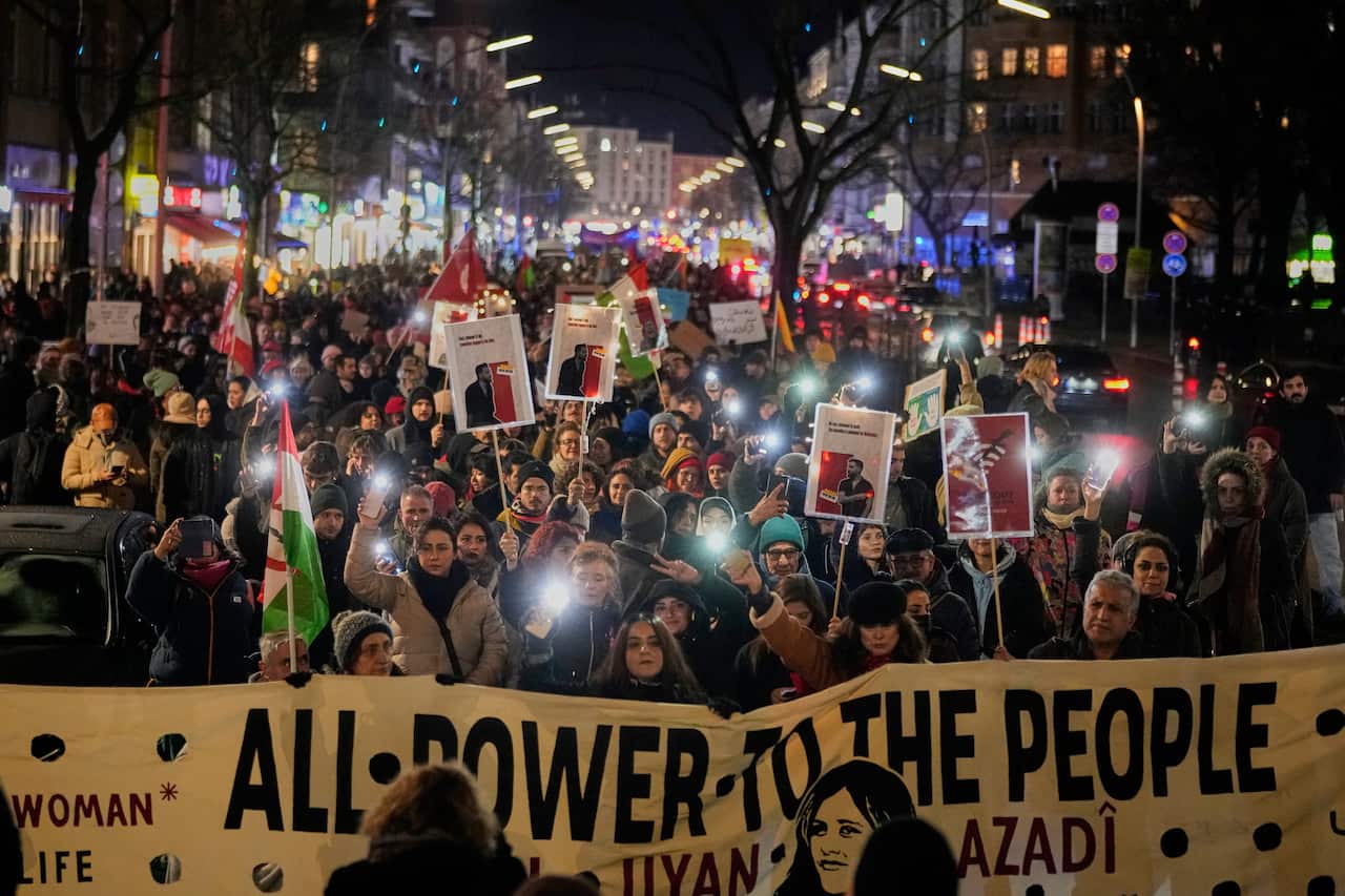 Crowd holds sign which reads, "All power to the people"