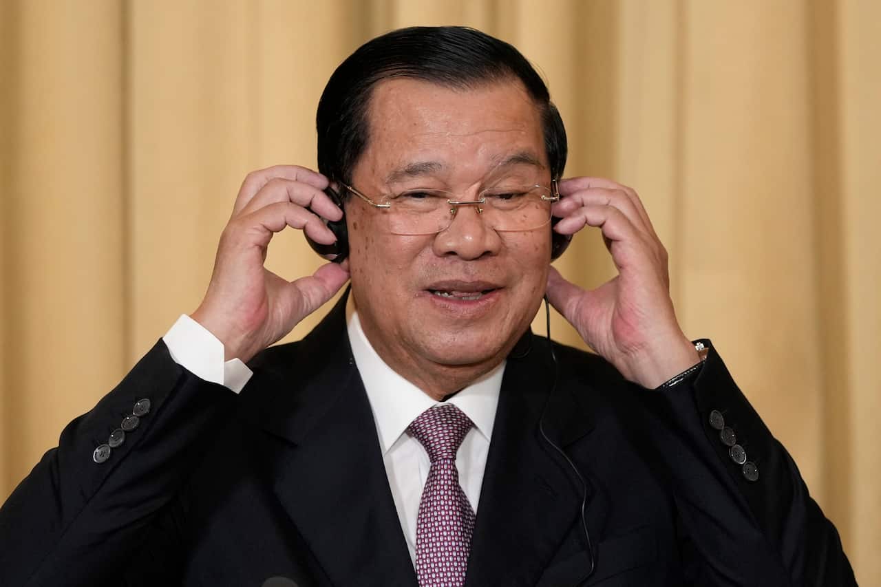 A man wearing a headphone at a press conference.