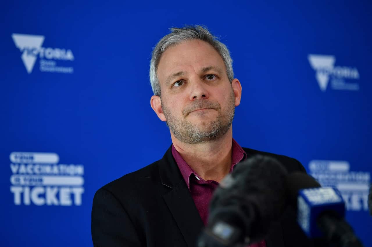 Victoria’s Chief Health Officer Professor Brett Sutton standing at podium with a microphone.