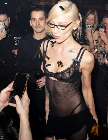 A man in black and a woman wearing a black open top at a party.