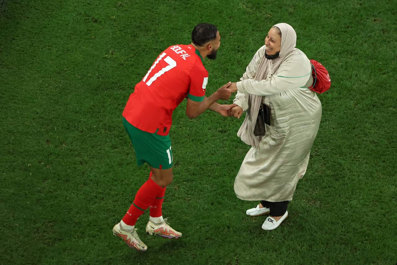 Two people seen dancing on a football field.