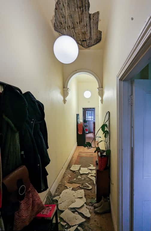 A ceiling partially collapsed, with debris on the floor.