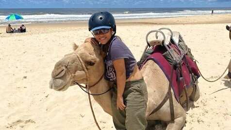 A girl and a camel on the beach