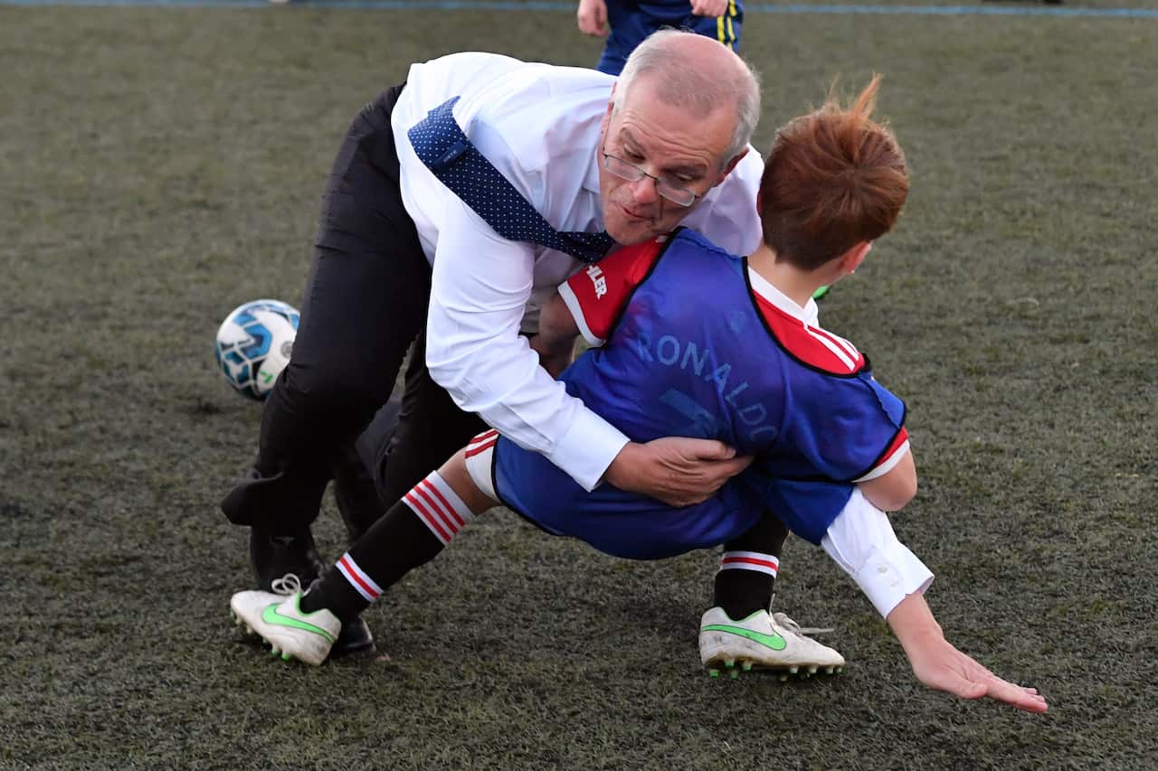 Prime Minister Scott Morrison accidentally knocking over a child on a football field during the day in Tasmania's Devonport. 