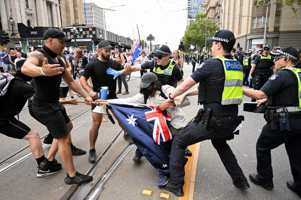 Police attempting to remove a protester from the street.