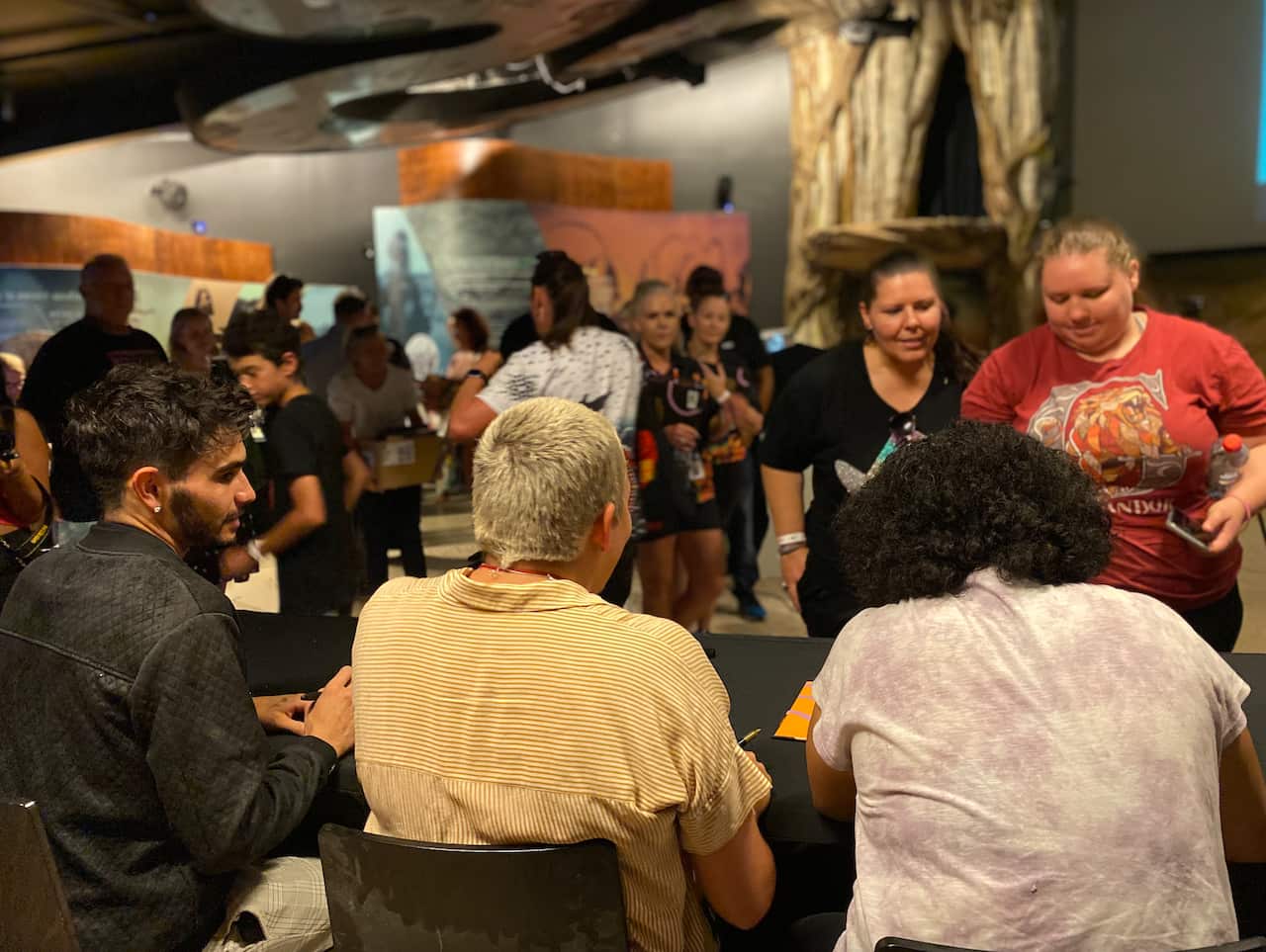 Isaiah Firebrace, Keisha Leon and Jaelyn Biumaiwai signing autographs during the book launch.