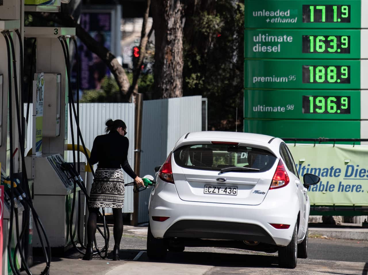 A woman filling up her car with petrol at a service station