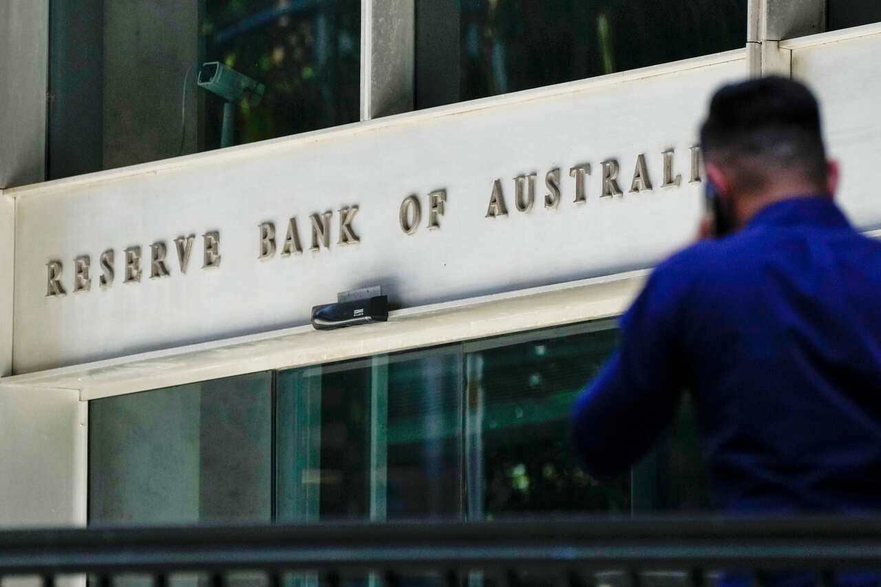 A man walks past the Reserve Bank of Australia building in Sydney, Australia.