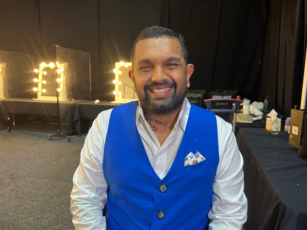 Dr Dinesh Palipana wearing dress shirt and vest, smiling at camera
