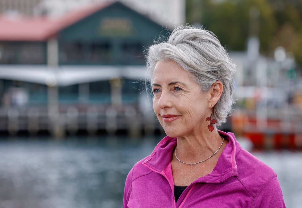 A portrait shot of a woman with short grey hair who is smiling gently.