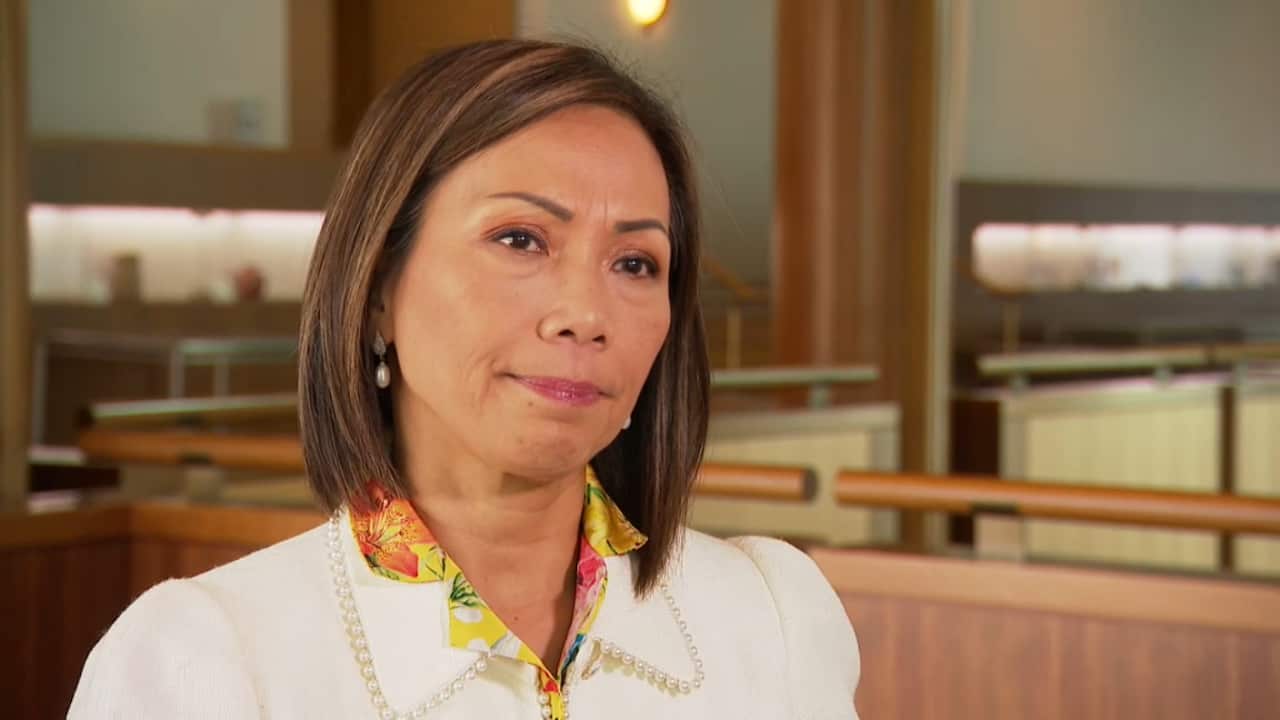 Dai Le looking concerned inside Parliament House.