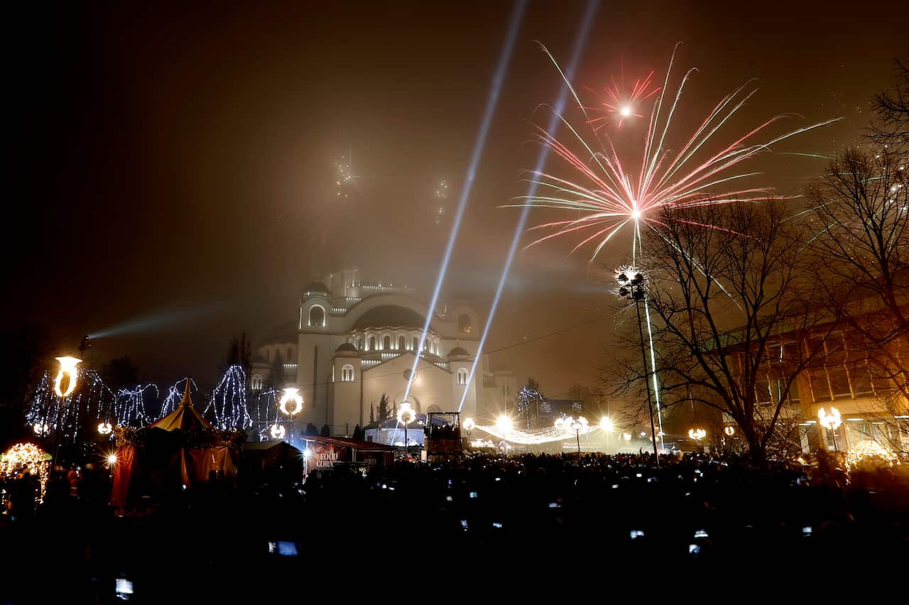 Fireworks over a church at night.