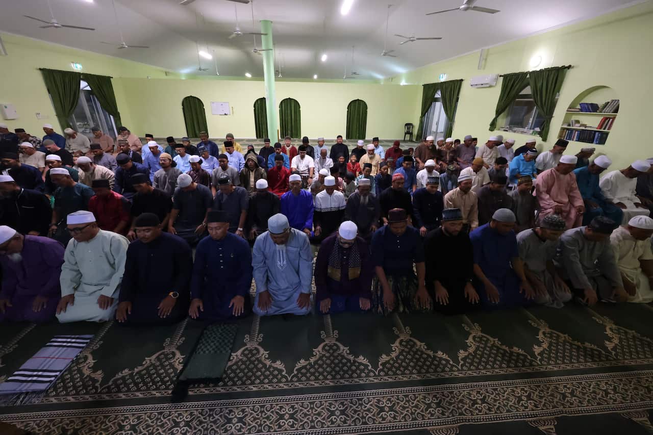 Members of the Coco Malay community offering prayers inside a mosque.