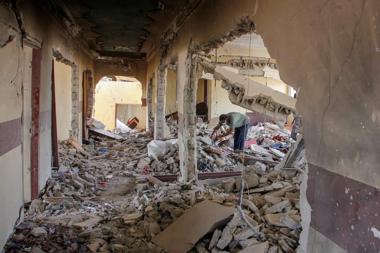 A man clears debris in the destroyed Hayat Hotel, days after a deadly siege by al-Shabab extremists, in Mogadishu, Somalia on 24 August 2022.