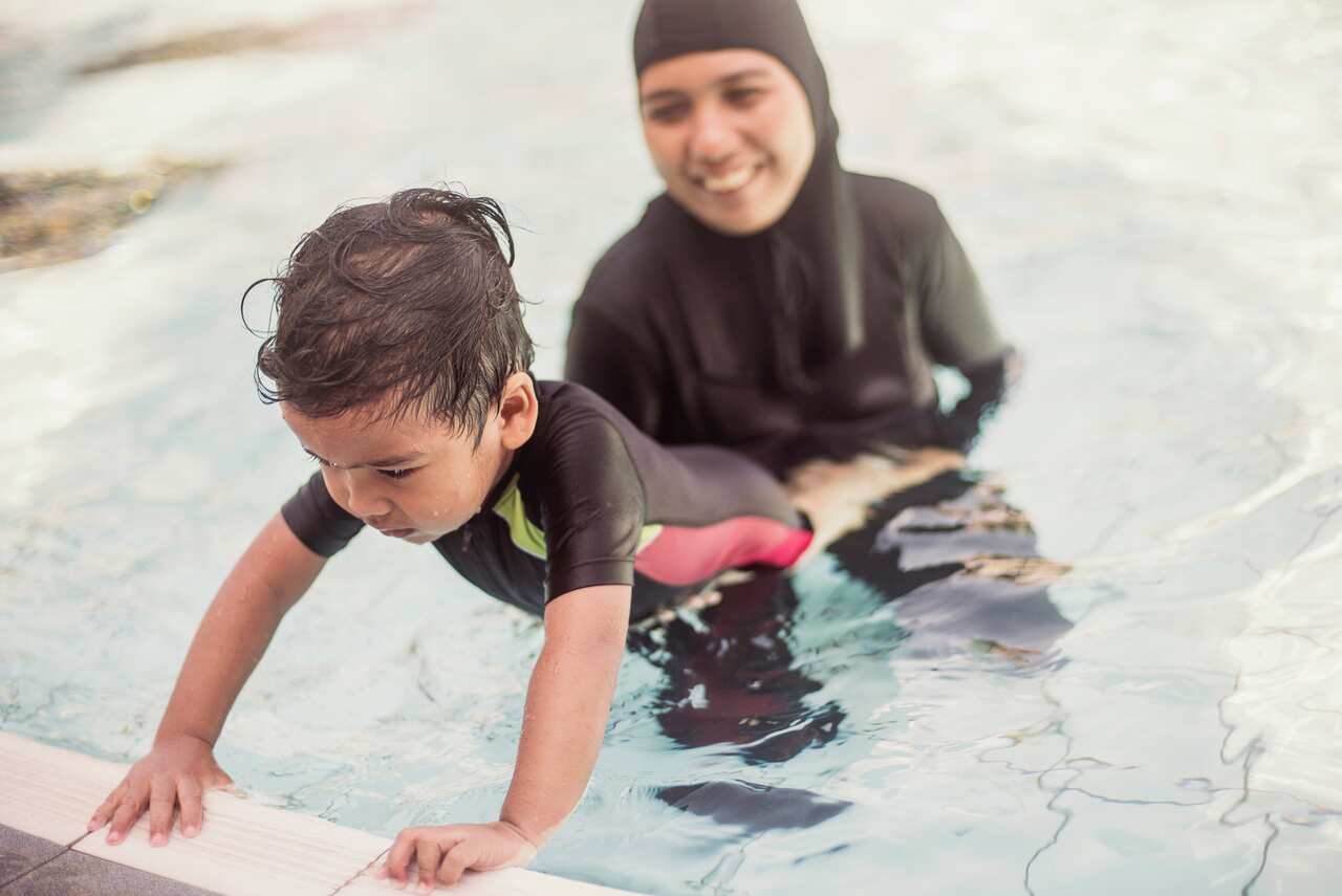Mother teaching her son how  to swim
