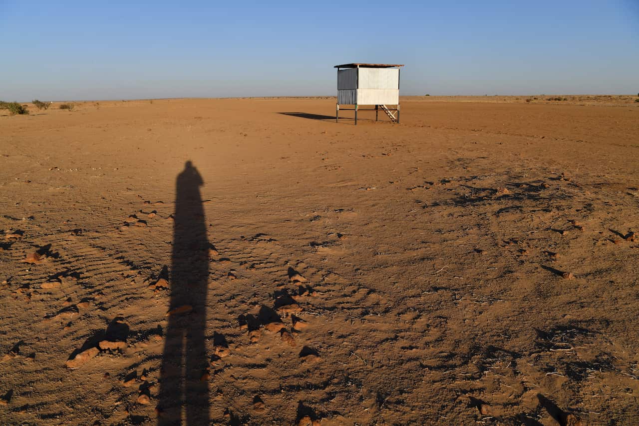 A small tin shed on stilts amid a red dirt landscape
