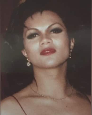 A close up shot of a woman with makeup, earrings and a necklace