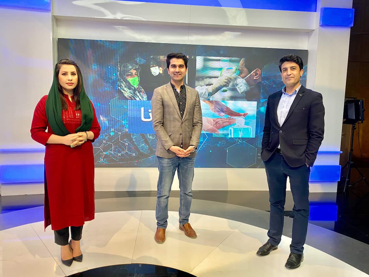 (left to right) A woman and two men standing in a television studio 