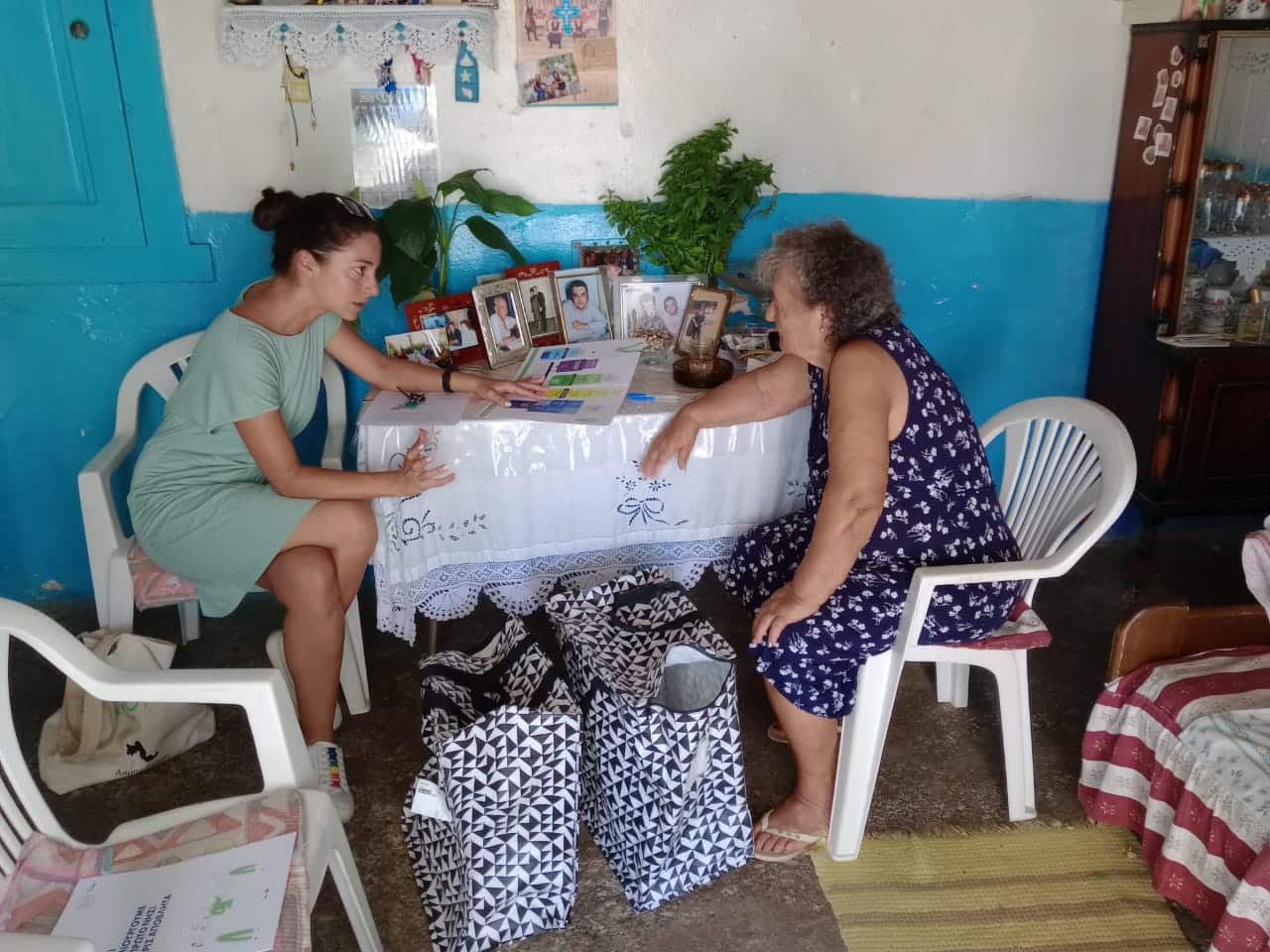 Two women sitting at a table in a small room.
