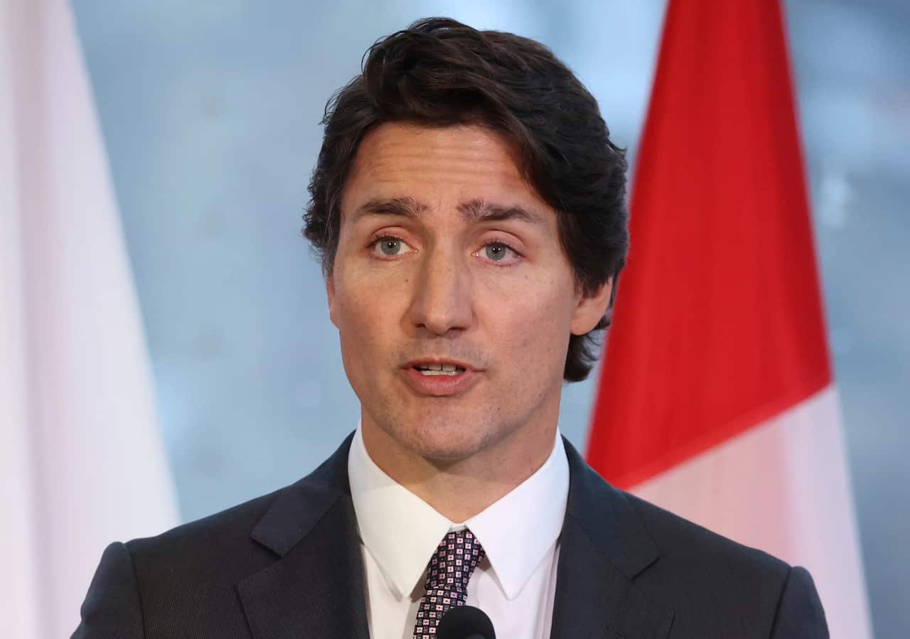 Justin Trudeau wearing a suit and talking into a microphone 