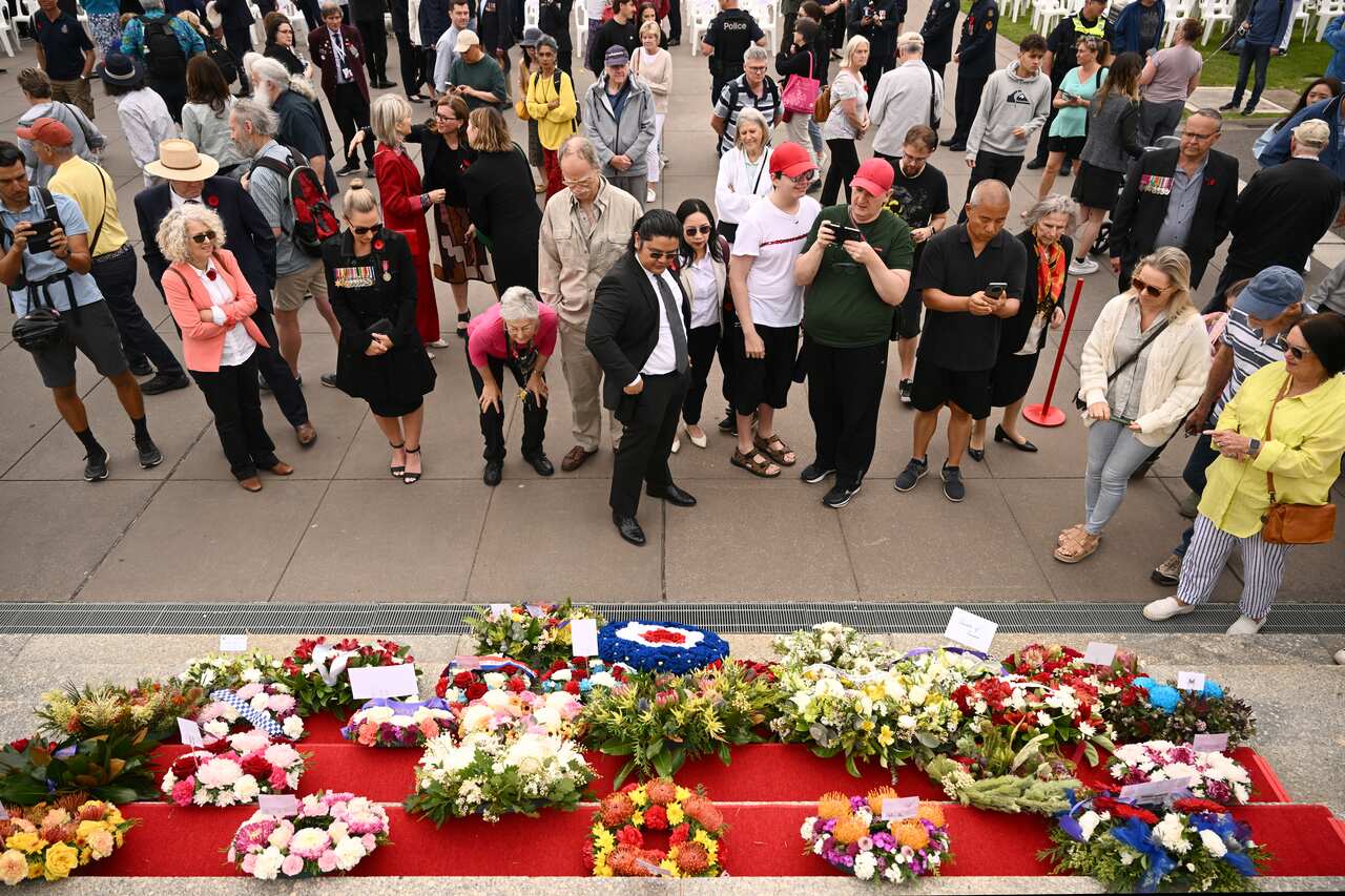People gather at a memorial.