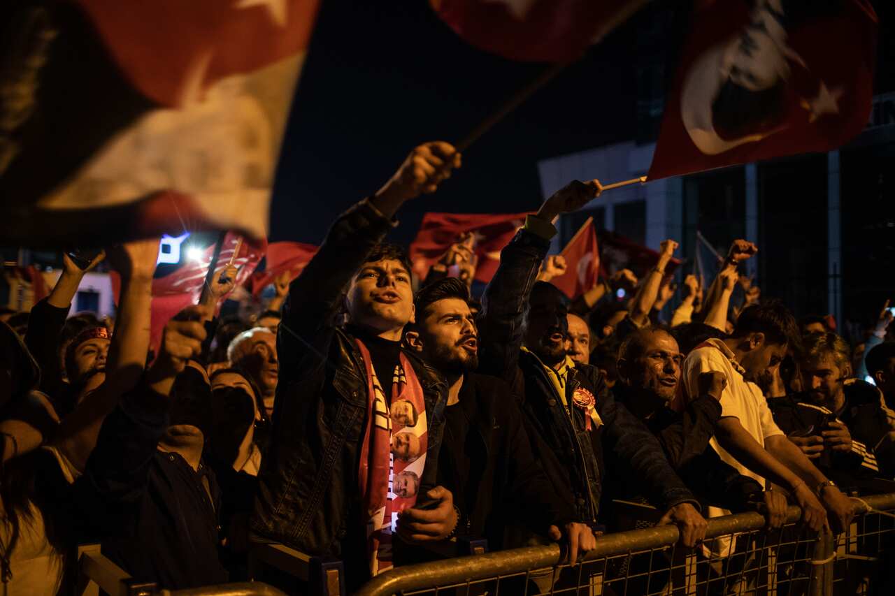 Turkish citizens at a rally waving Turkish flags.