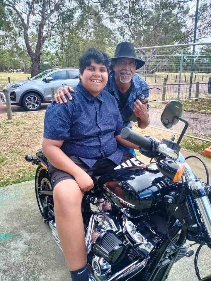 Cassius Turvey on a black motorcycle, with his dad Sam beside hiim