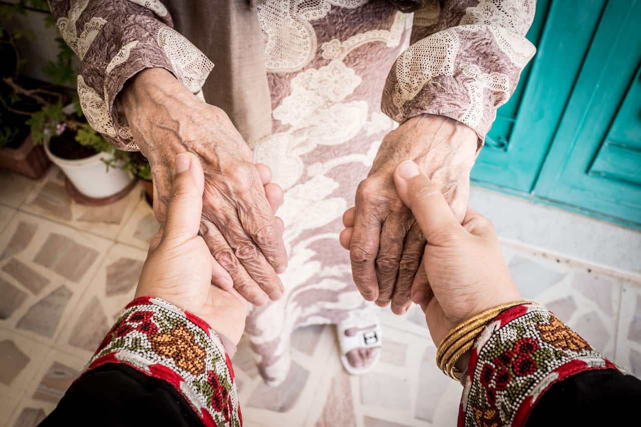 Holding hands of senior woman