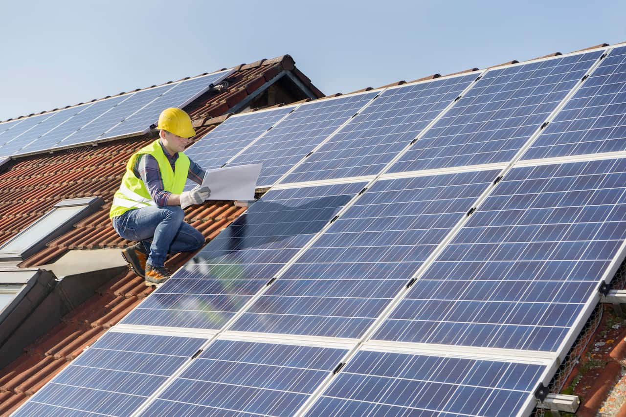 Engineer on roof controlling solar panels