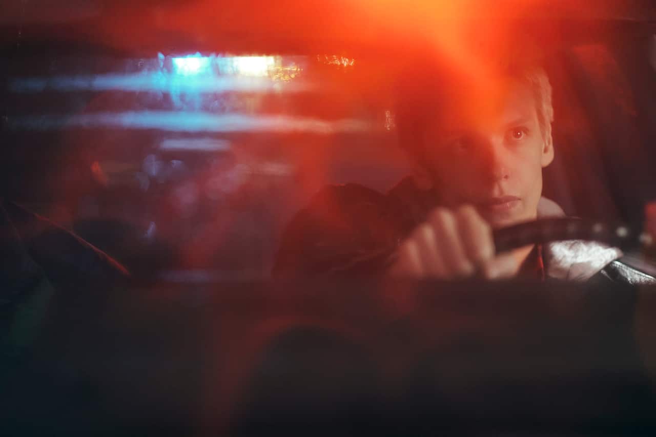 A young man driving a car at night.jpg