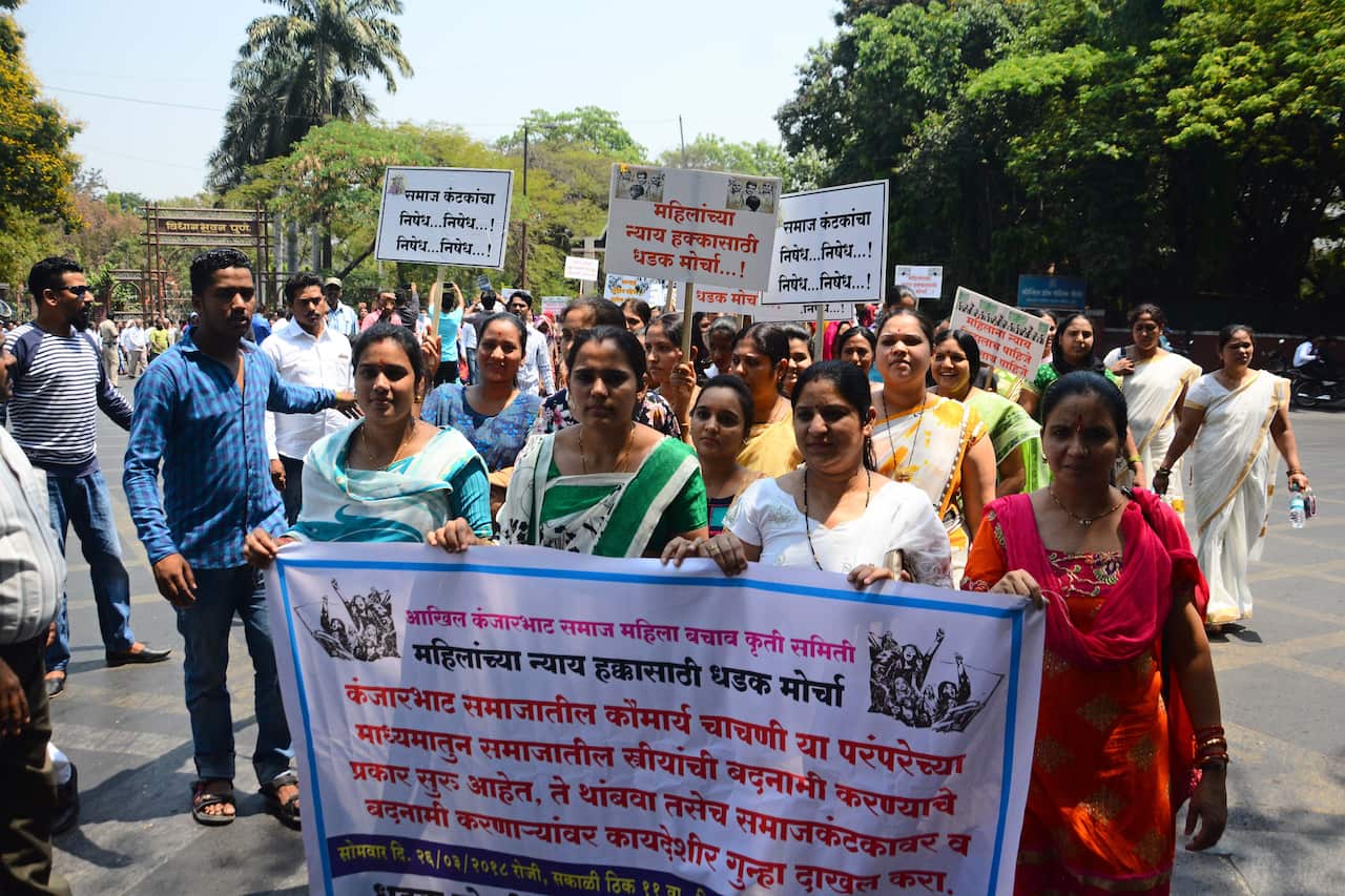 Kanjarbhat community members, in support of the virginity ritual, hold placards and march in 2018 in Pune, India.