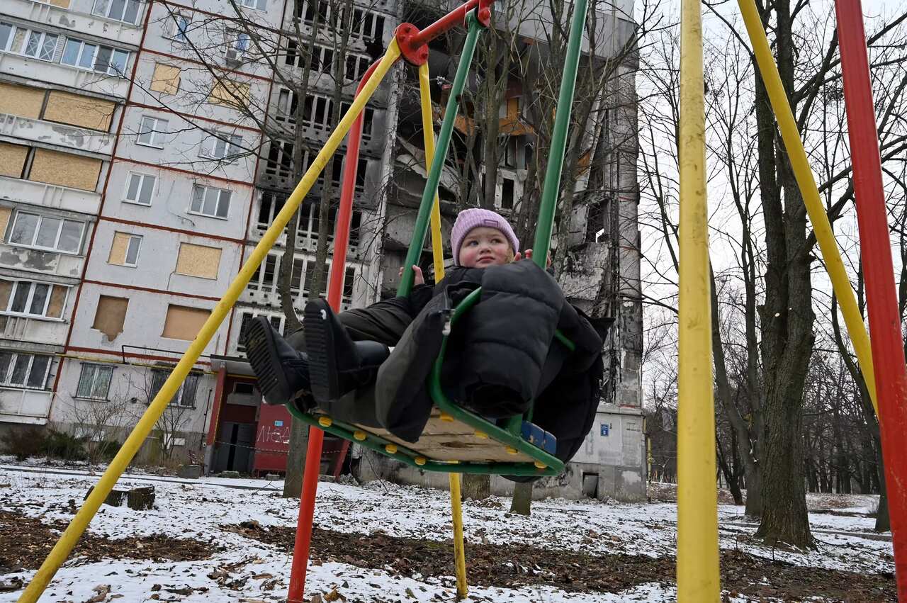 A child uses a swing in an empty playground in Ukraine.