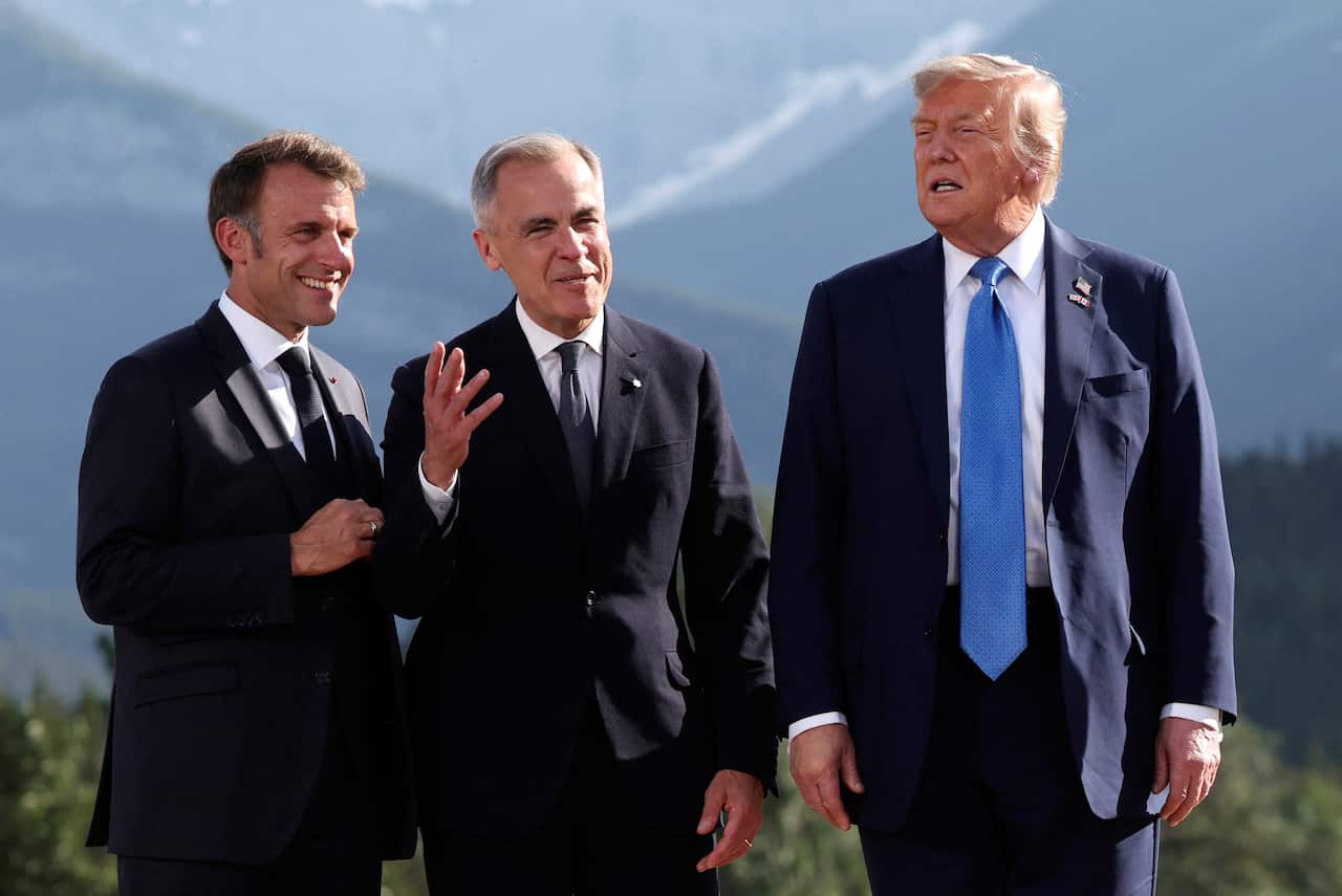 French Prime Minister Emmanuel Macron, Canada's Prime Minister Mark Carney, and US President Donald Trump, wearing suits and ties, standing outside. 