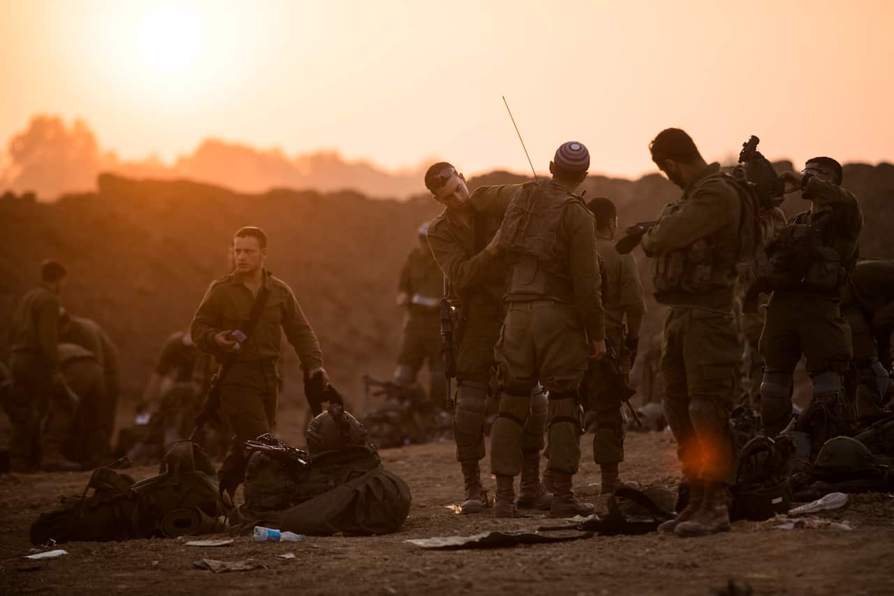 Israeli soldiers organise their equipment near the border with the Gaza Strip.