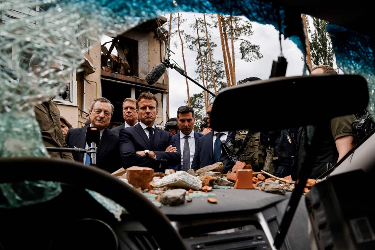 Leaders examine wreckage of a car