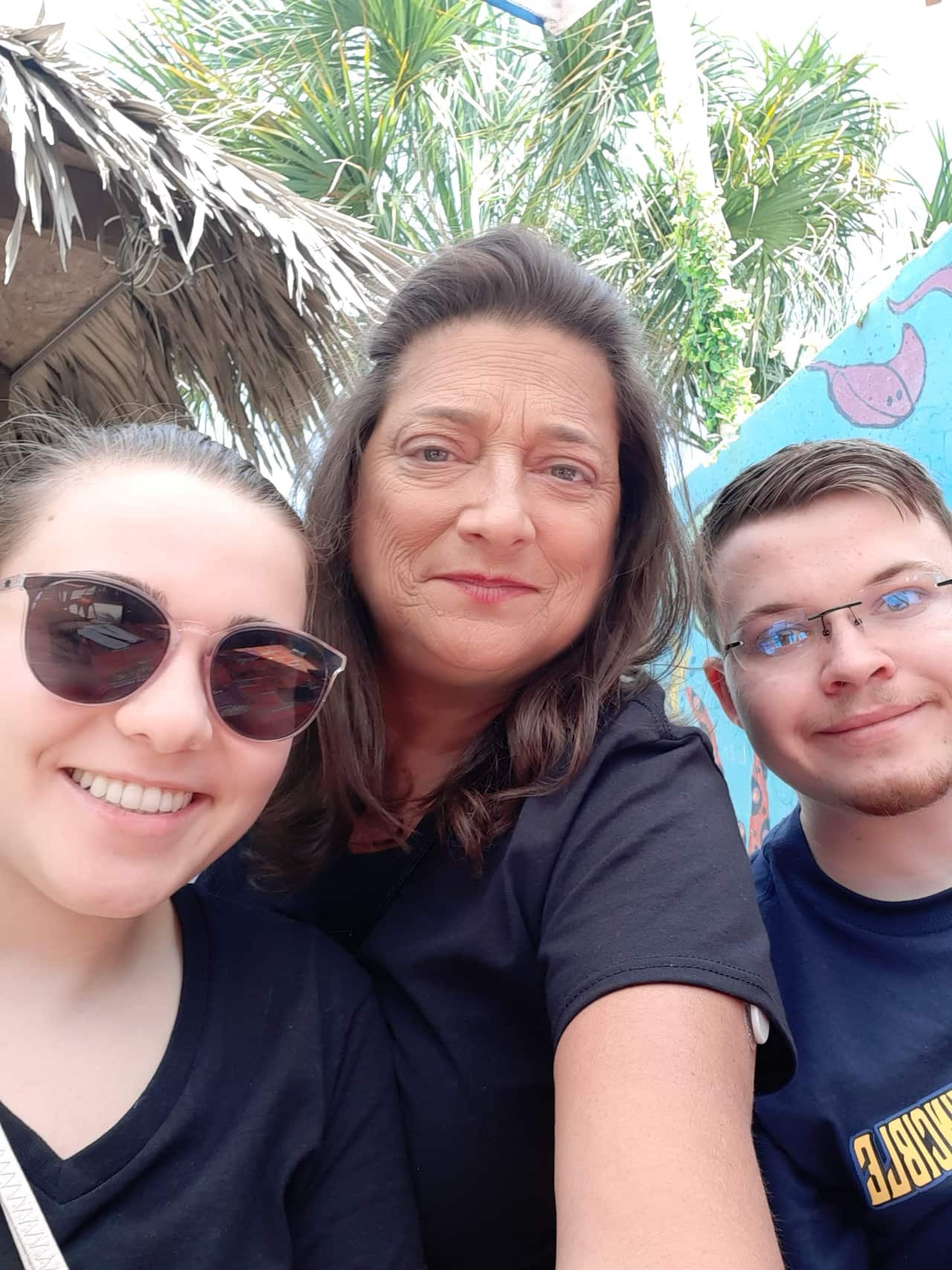 A mother taking a selfie with her two children.