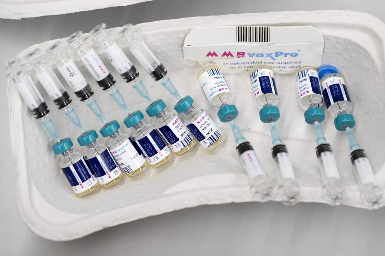 A neat row of needles and serum bottles laid out in a tray