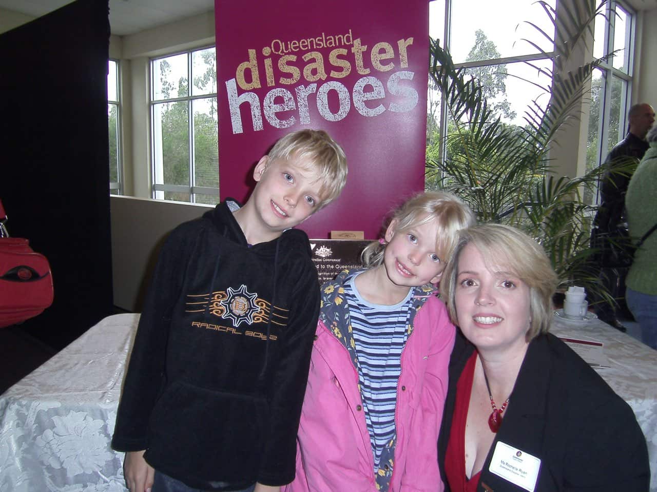 A mother crouching beside her two young children inside